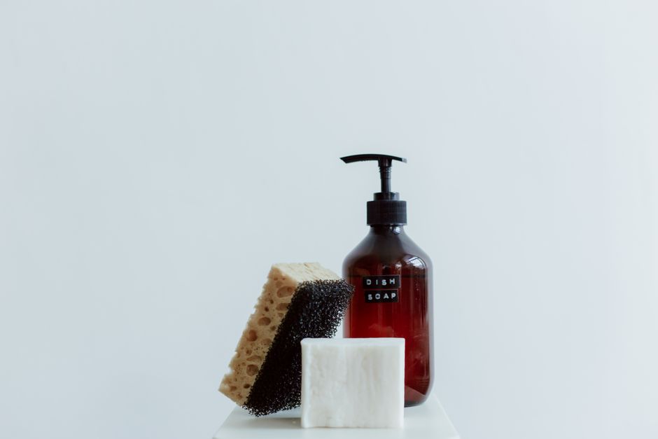 Stylish arrangement of dish soap, sponge, and bar soap in a minimalist setting.