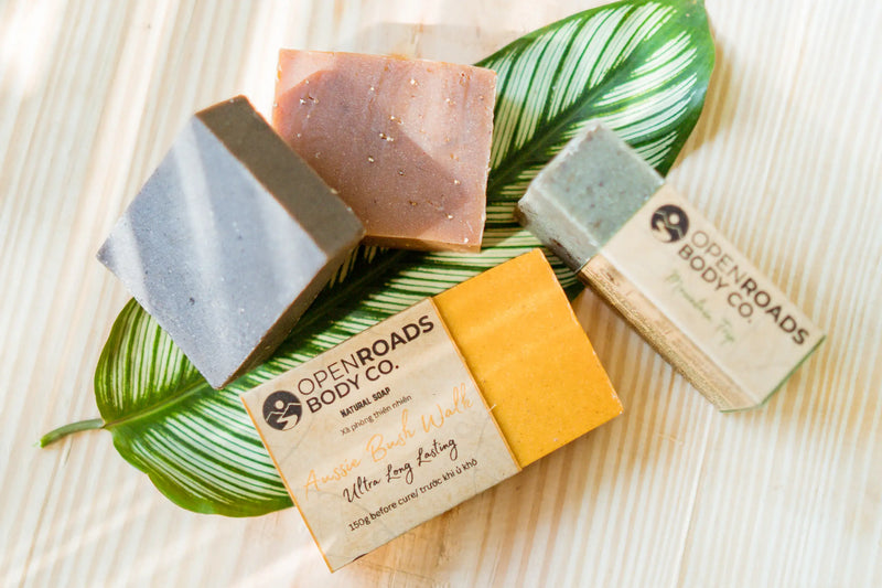 Natural soap bars from Open Roads Body Co on leaf, wooden surface, eco-friendly skincare