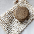 Round natural soap bar on a woven cotton soap saver pouch, eco-friendly and sustainable